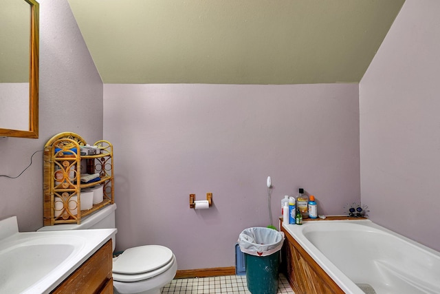 bathroom featuring a bath, vaulted ceiling, vanity, and toilet