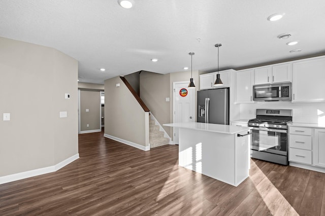 kitchen featuring a center island, dark hardwood / wood-style floors, decorative light fixtures, white cabinetry, and stainless steel appliances