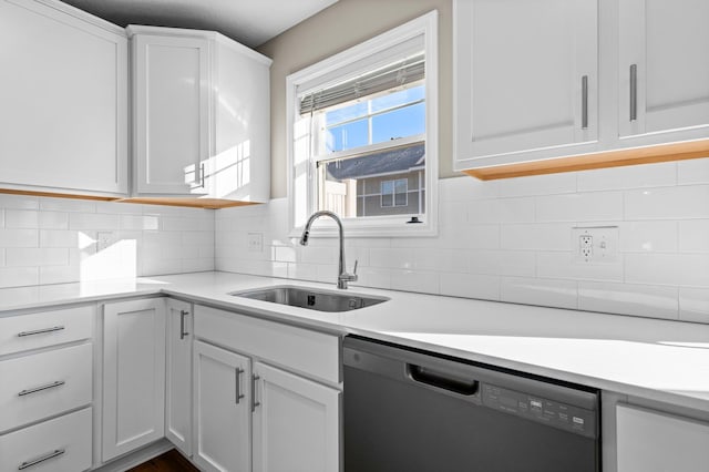 kitchen with decorative backsplash, white cabinetry, dishwasher, and sink