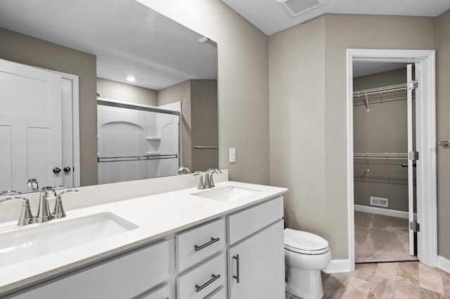 bathroom featuring vanity, toilet, and walk in shower