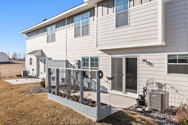 back of house featuring a yard, central AC, and a patio area