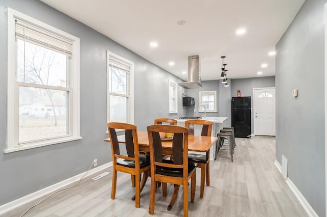 dining area featuring sink and light hardwood / wood-style floors