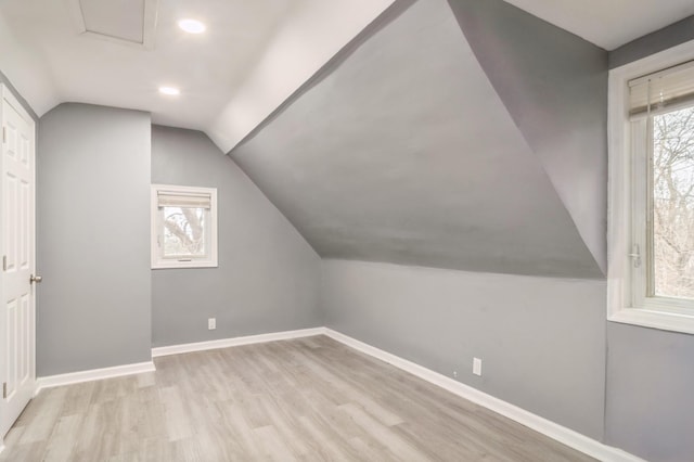 additional living space with lofted ceiling and light hardwood / wood-style flooring