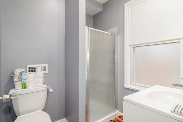 bathroom with vanity, toilet, and a shower with shower door