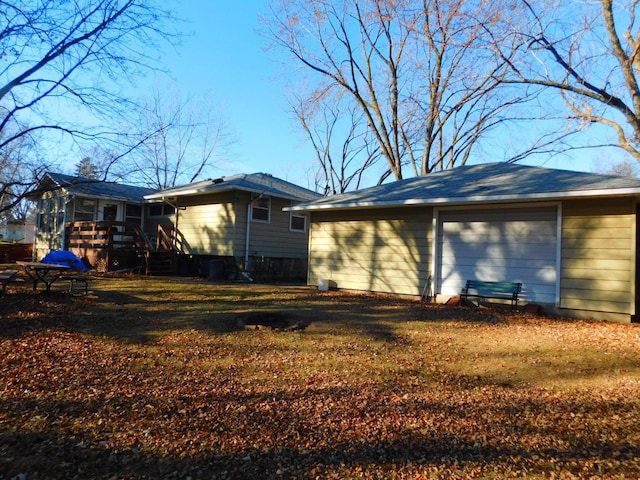 rear view of house with a garage and a wooden deck