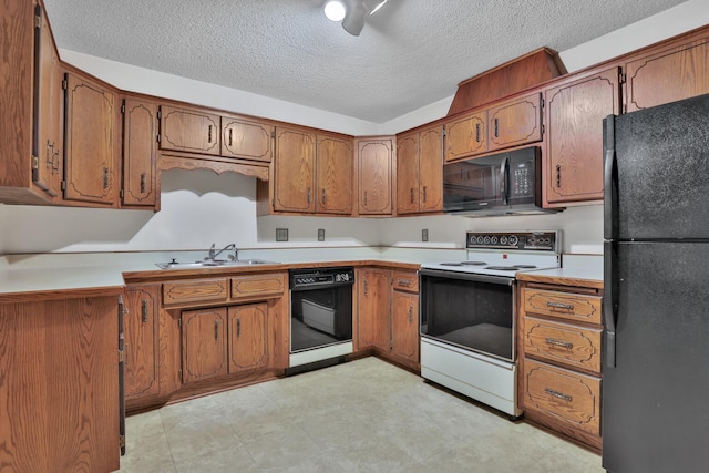 kitchen featuring black appliances, a textured ceiling, and sink