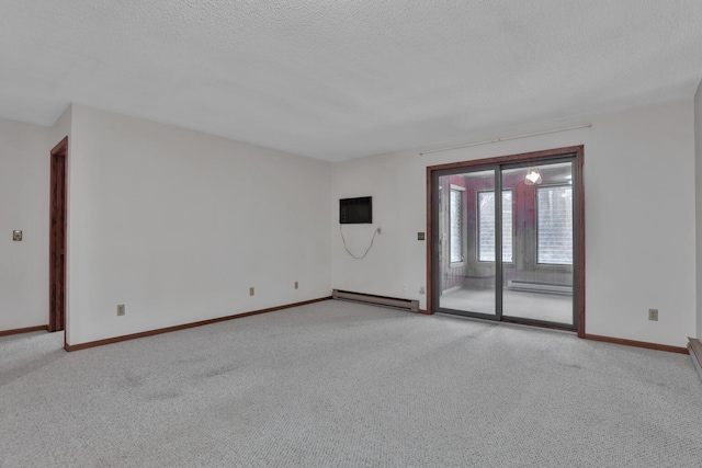 carpeted empty room featuring baseboard heating and a textured ceiling