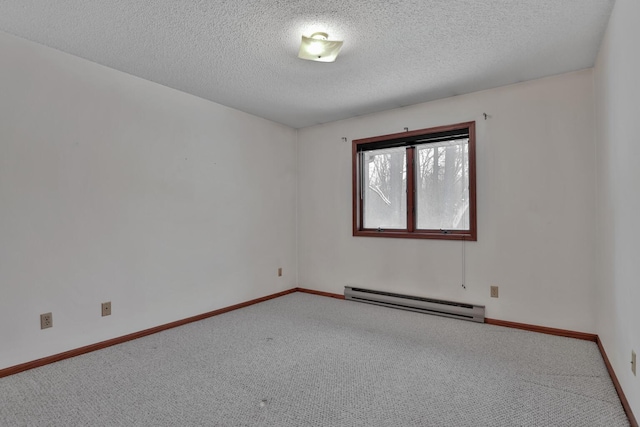 carpeted empty room featuring baseboard heating and a textured ceiling