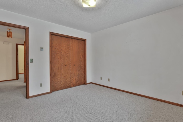 unfurnished bedroom with carpet flooring, a closet, and a textured ceiling