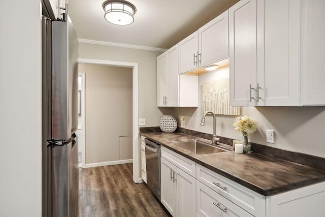 kitchen featuring sink, dark wood-type flooring, stainless steel appliances, crown molding, and white cabinets