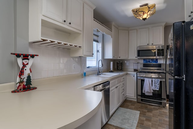 kitchen featuring backsplash, white cabinetry, sink, and appliances with stainless steel finishes