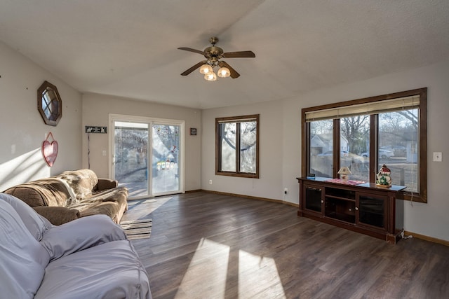 living room featuring ceiling fan, a healthy amount of sunlight, and dark wood-type flooring