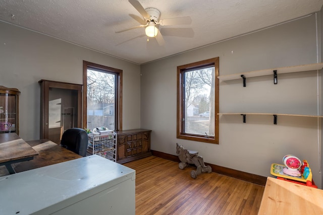 office space with ceiling fan, a textured ceiling, and hardwood / wood-style flooring