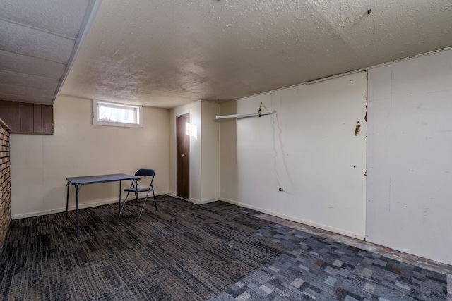 basement with dark carpet and a textured ceiling