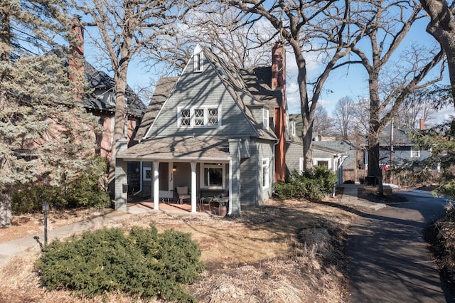 view of front of home featuring covered porch and a chimney