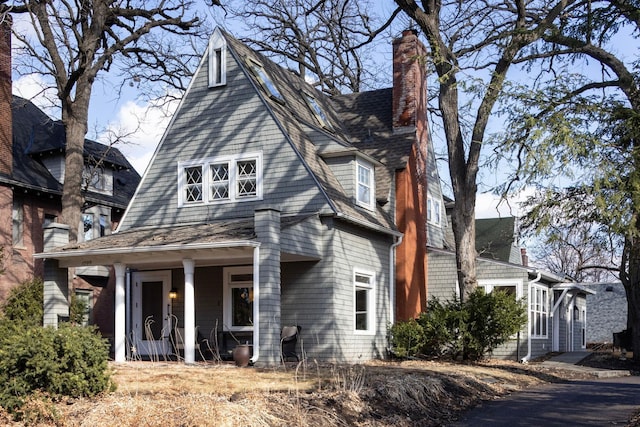 shingle-style home with a shingled roof and a chimney