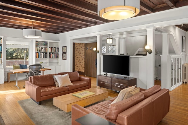 living room with stairs, beamed ceiling, and wood-type flooring