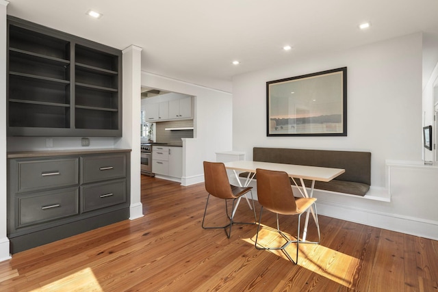 dining room featuring baseboards, light wood finished floors, and recessed lighting