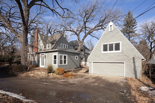 view of home's exterior with a garage and a chimney