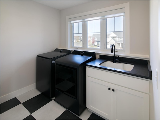 laundry room featuring cabinets, separate washer and dryer, and sink