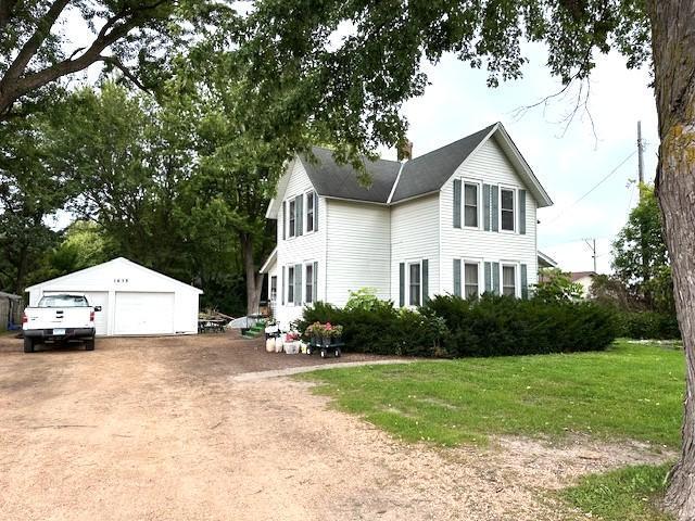 colonial home with an outbuilding, a front lawn, and a garage