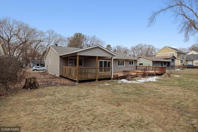 rear view of property featuring a wooden deck and a yard