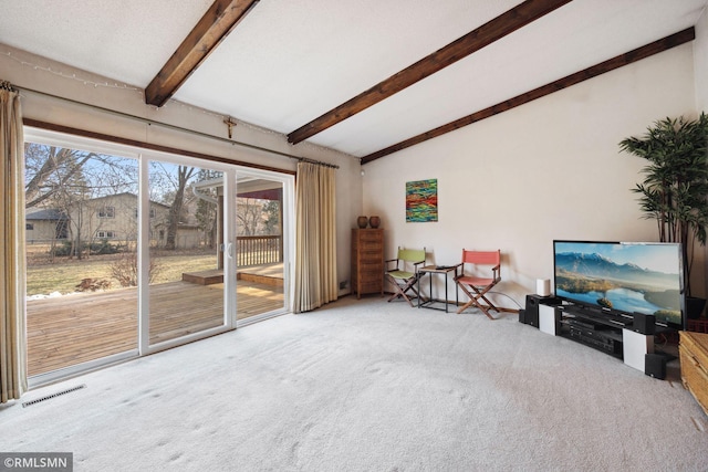 carpeted living room featuring lofted ceiling with beams