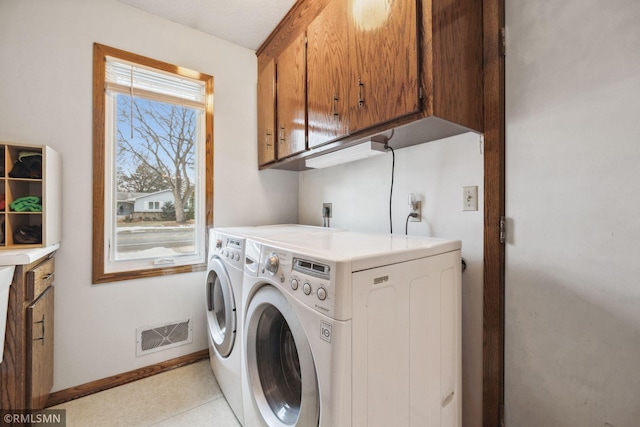 washroom featuring independent washer and dryer and cabinets