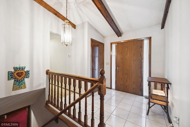 tiled foyer entrance featuring lofted ceiling with beams and a chandelier