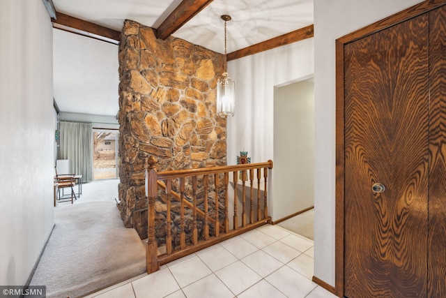 hallway featuring beam ceiling, a chandelier, and light carpet