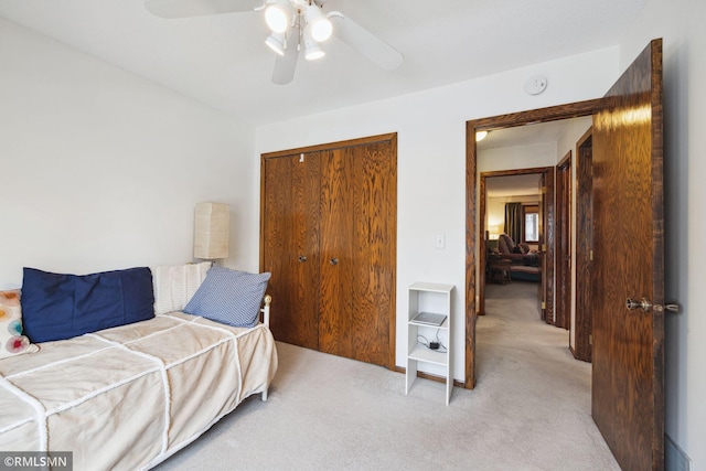 carpeted bedroom featuring ceiling fan and a closet