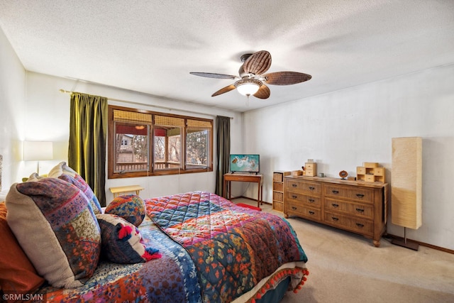 bedroom featuring ceiling fan, light colored carpet, and a textured ceiling