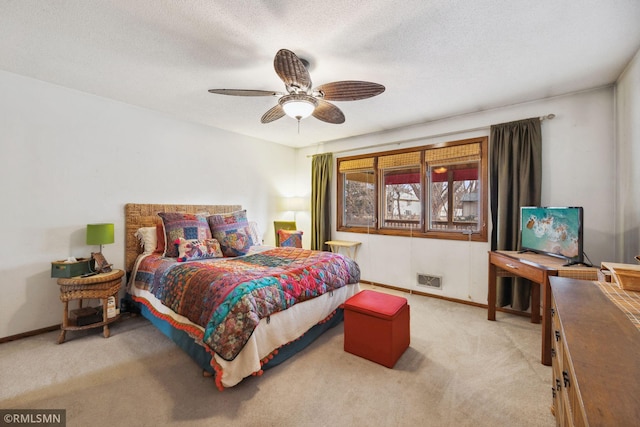 bedroom with light colored carpet, a textured ceiling, and ceiling fan