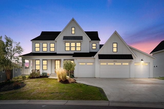 modern farmhouse style home featuring a garage and a lawn