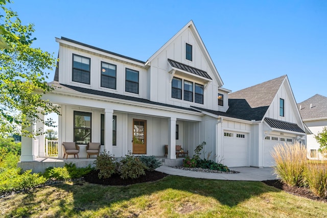 modern farmhouse featuring a garage, covered porch, and a front yard