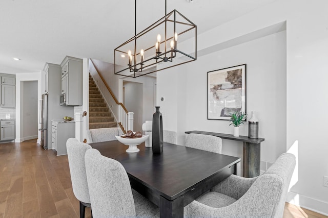 dining space featuring wood-type flooring and a chandelier