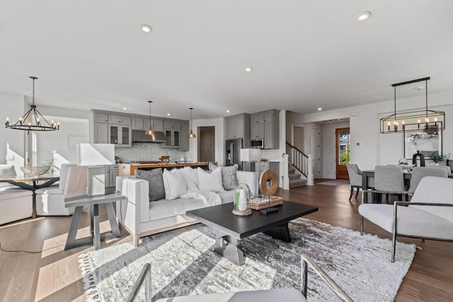 living room with dark wood-type flooring and a notable chandelier