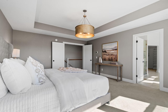 bedroom featuring a tray ceiling and carpet flooring