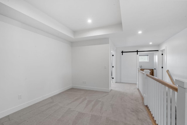 interior space featuring a barn door and a raised ceiling