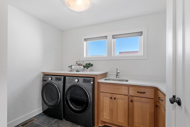 washroom featuring a healthy amount of sunlight, sink, and washer and dryer