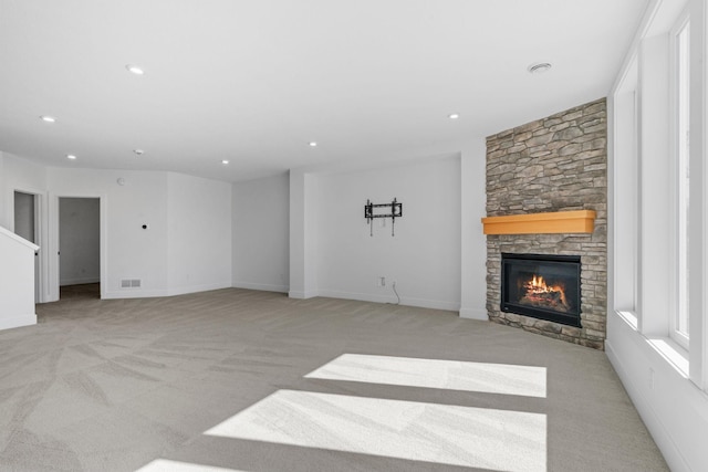 unfurnished living room with light colored carpet and a fireplace