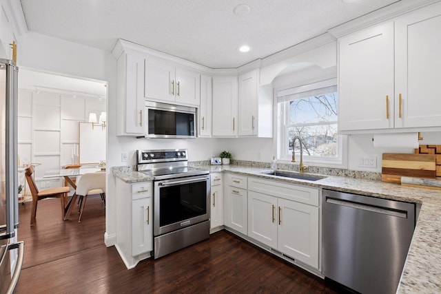 kitchen featuring a sink, stainless steel appliances, dark wood-type flooring, and white cabinetry