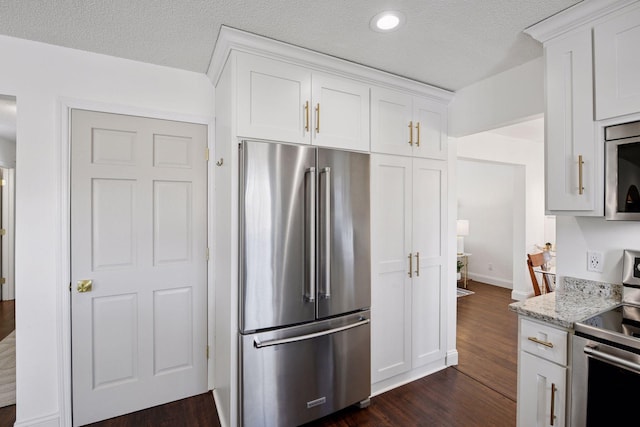 kitchen featuring dark wood finished floors, white cabinetry, appliances with stainless steel finishes, and a textured ceiling