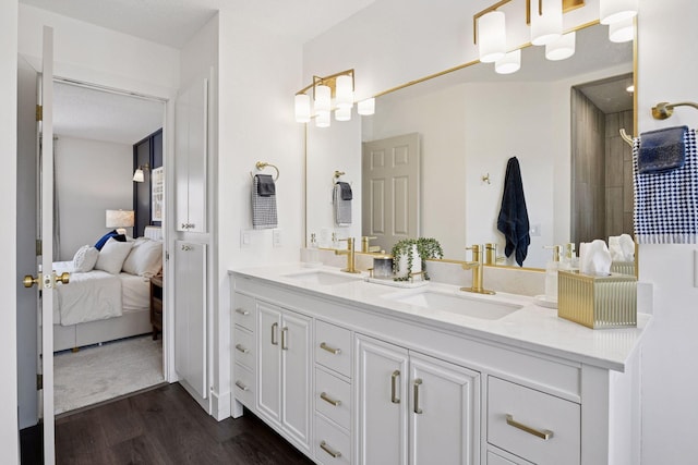 bathroom featuring double vanity, connected bathroom, wood finished floors, and a sink