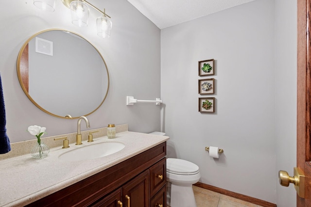 half bath with vanity, baseboards, visible vents, tile patterned floors, and toilet