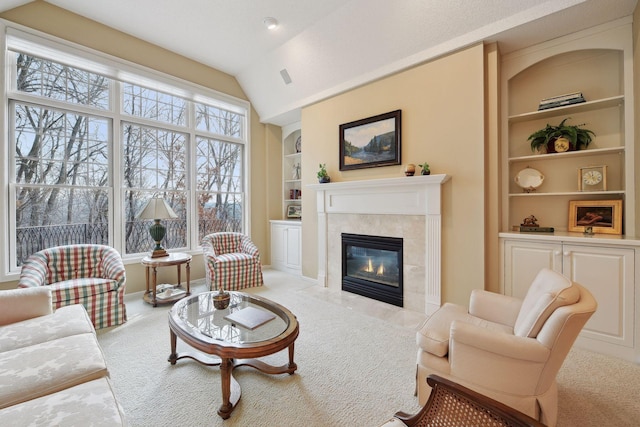 living room with a fireplace, carpet, vaulted ceiling, and built in features