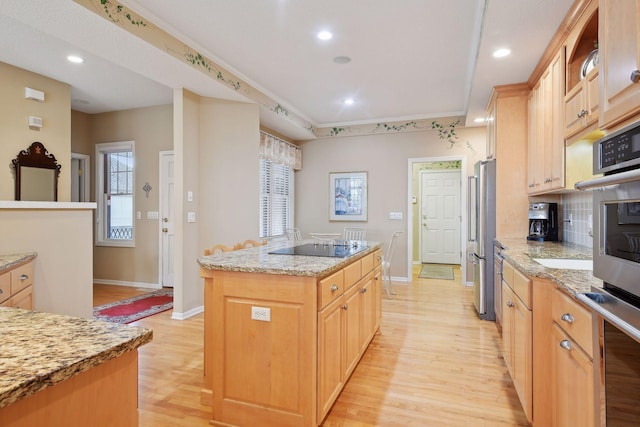 kitchen with light stone countertops, stainless steel fridge, light brown cabinetry, a center island with sink, and light wood-type flooring