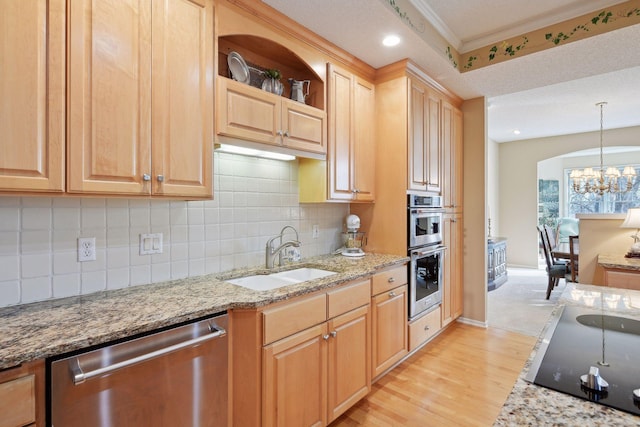 kitchen with sink, light hardwood / wood-style floors, a chandelier, decorative light fixtures, and appliances with stainless steel finishes