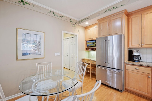 kitchen featuring light stone countertops, light brown cabinets, light hardwood / wood-style floors, high end fridge, and ornamental molding