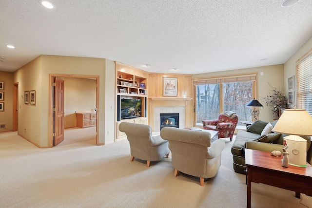 living room with a textured ceiling, light colored carpet, built in features, and a fireplace